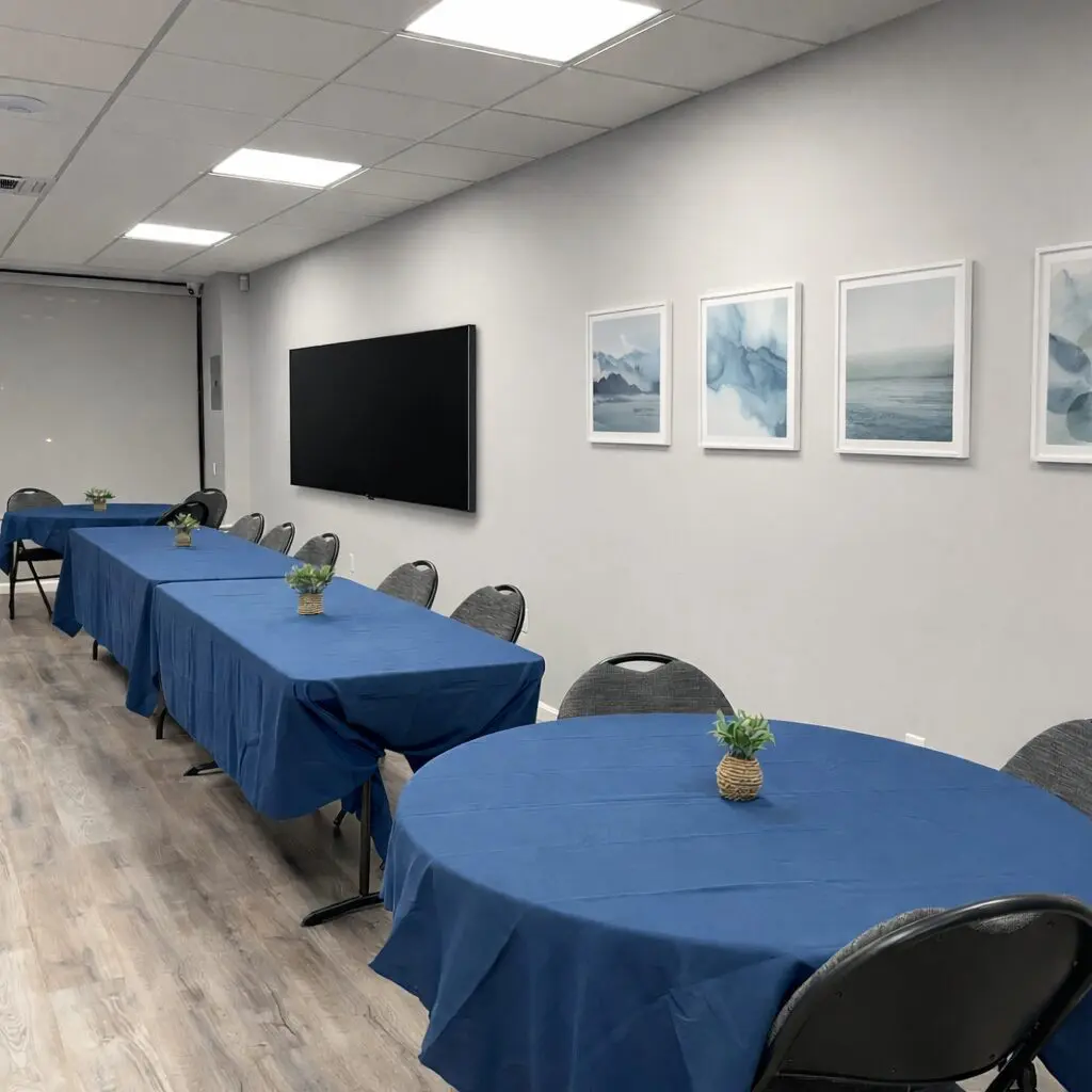 Meeting room with blue tablecloths and wall art.