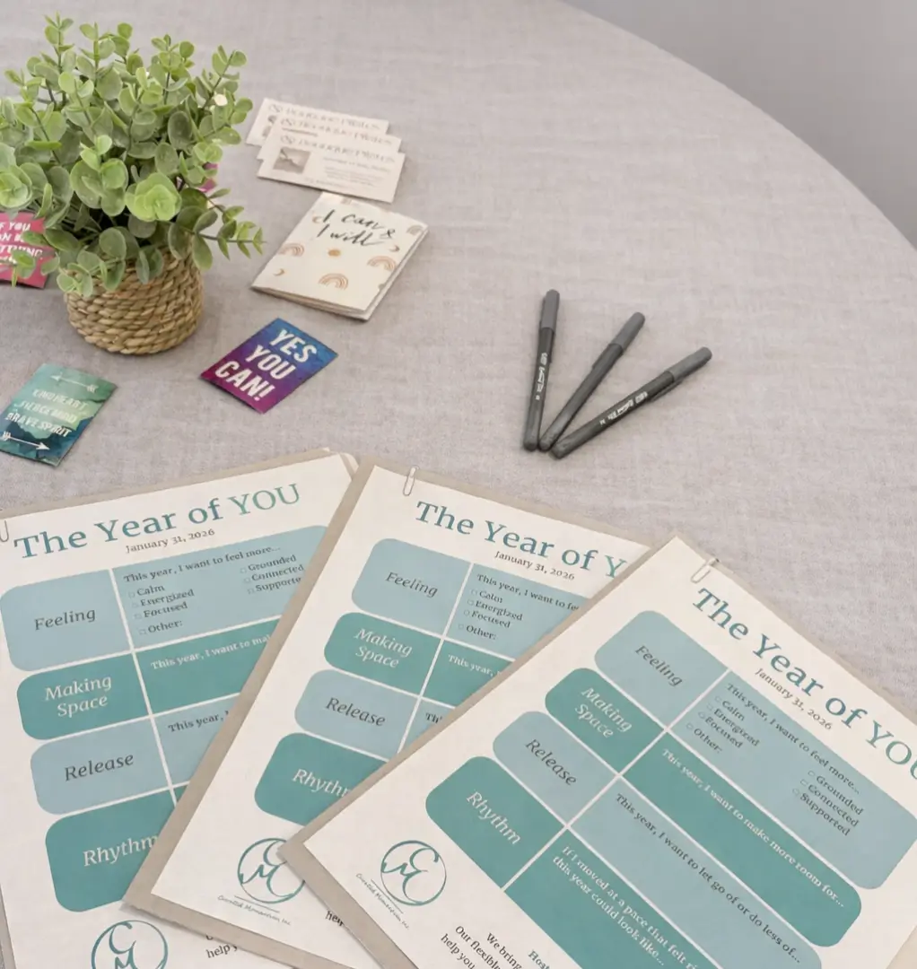 Planners and pens on a table with plant.
